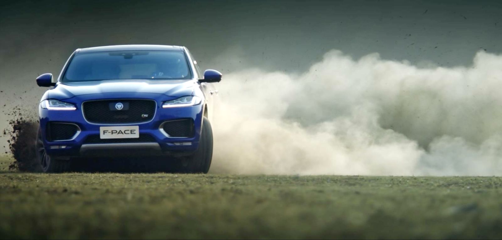 The blue F-Pace driving hard through dust